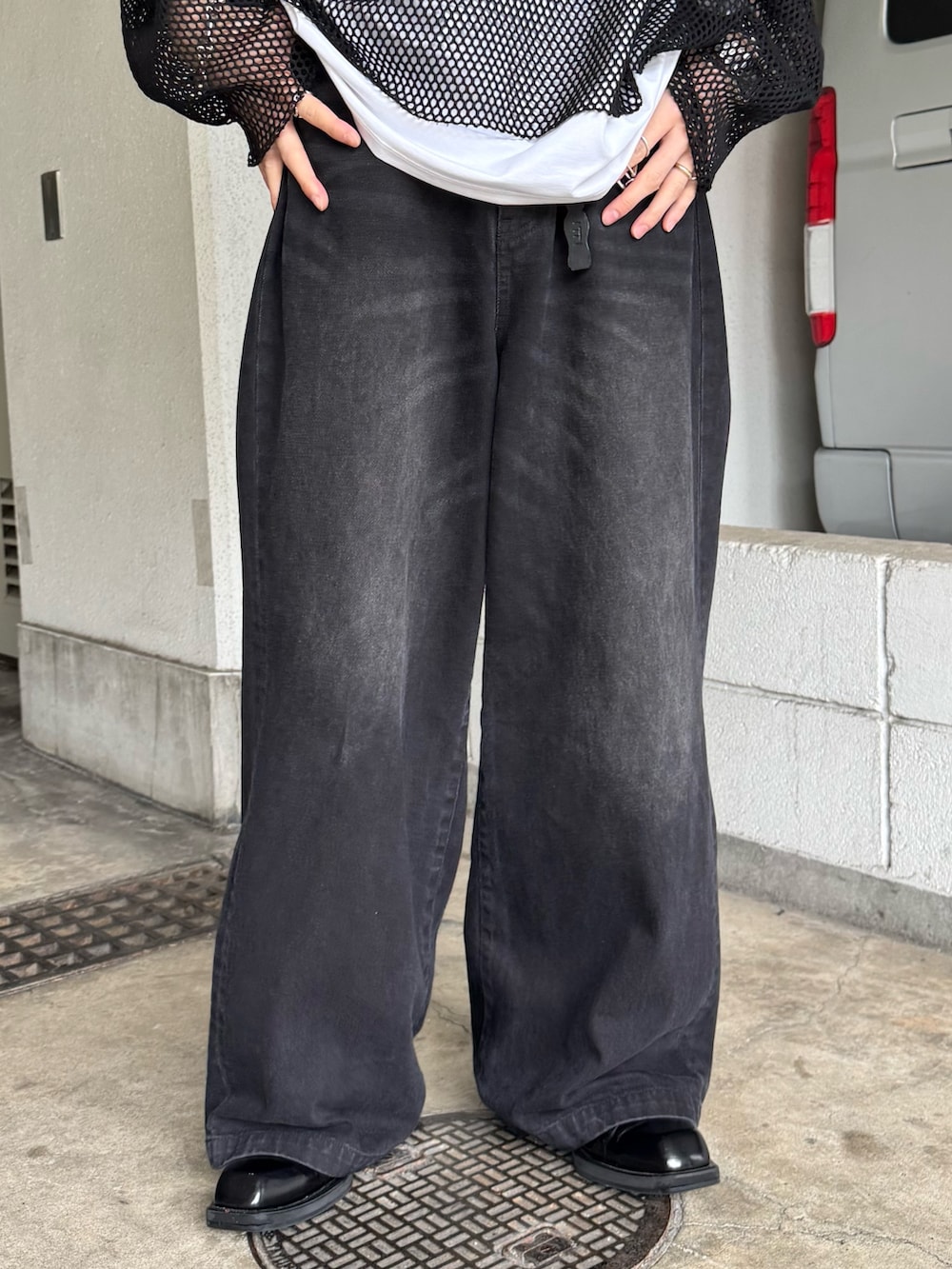 ブラック系のTシャツ/カットソー、ブラック系のデニムパンツ、ホワイト系のTシャツ/カットソーを着用したメンズの夏コーディネートの4枚目の写真