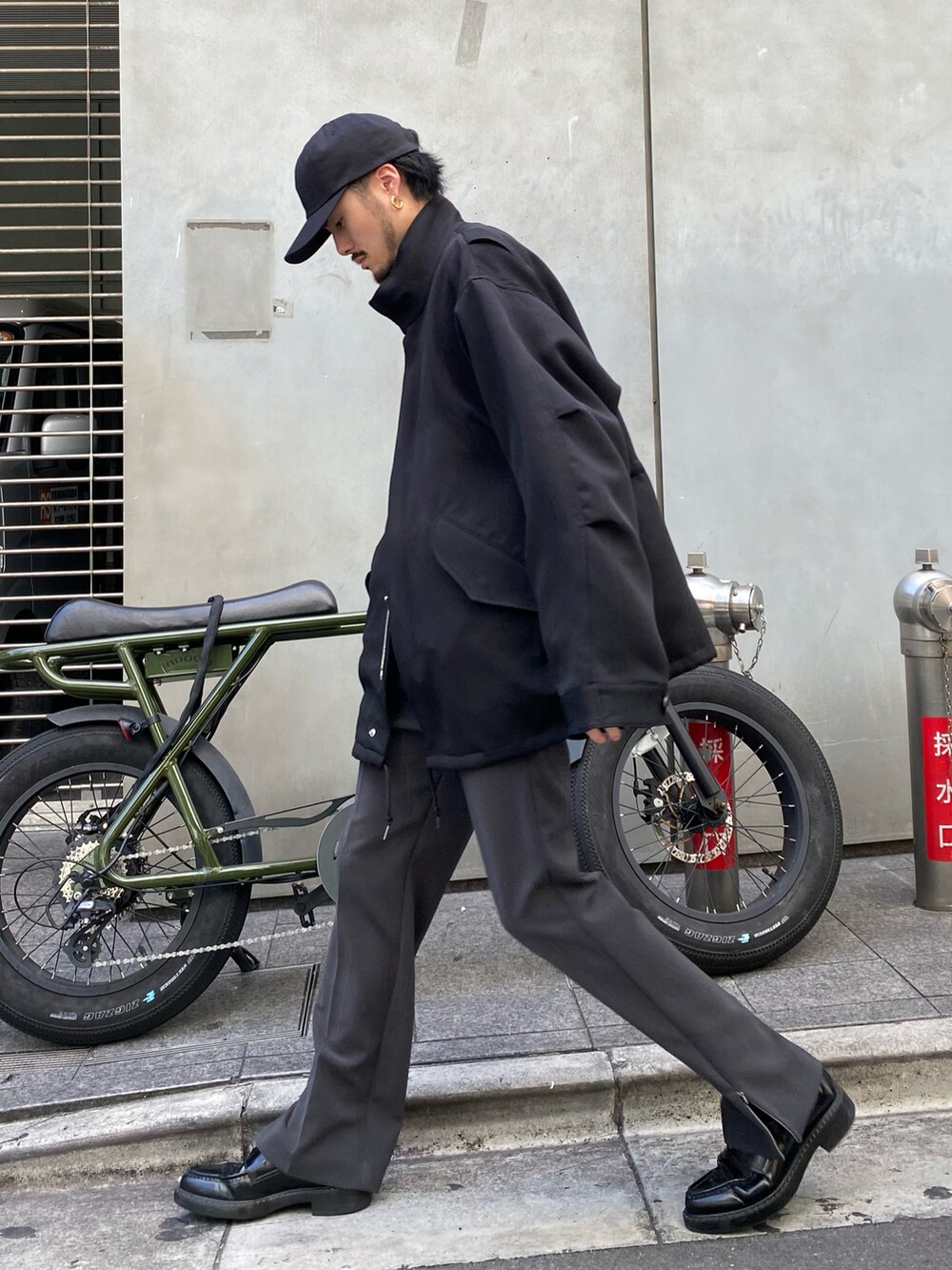 ブラック系のモッズコート、グレー系のスラックスを着用したメンズの秋コーディネートの2枚目の写真