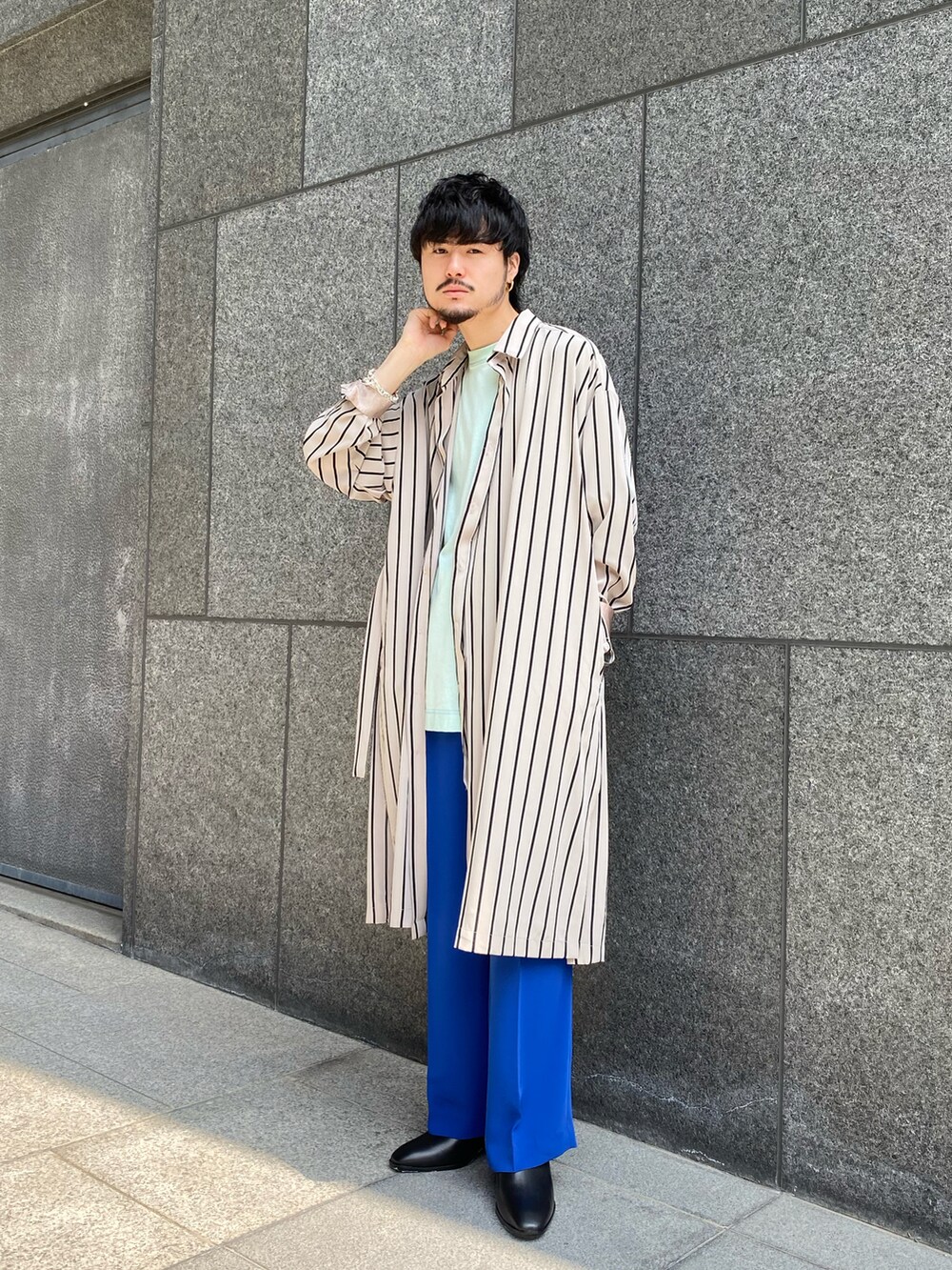 ベージュ系のシャツ/ブラウス、ブルー系のスラックス、ブラック系のドレスシューズを着用したメンズの春コーディネートの2枚目の写真