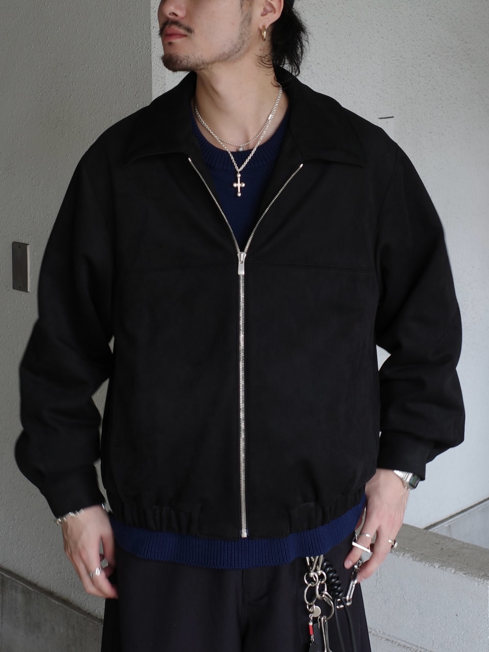 ブラック系のブルゾン、ブルー系のニット/セーター、ブラック系のスラックスを着用したメンズの冬コーディネートの4枚目の写真