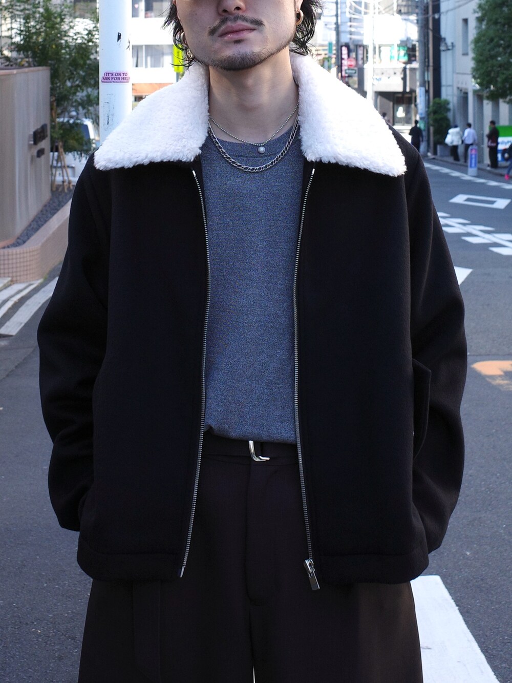 グレー系のニット/セーター、ブラック系のブルゾン、グレー系のスラックスを着用したメンズの秋コーディネートの6枚目の写真