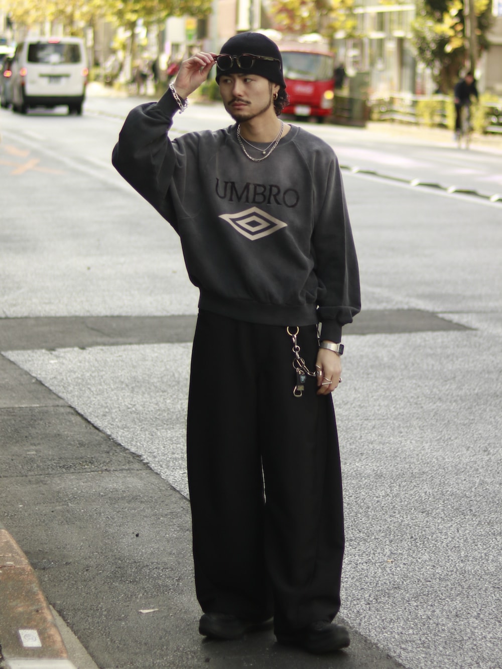 グレー系のスウェット、ブラック系のスラックス、ブラック系のキーホルダーを着用したメンズの冬コーディネートの2枚目の写真