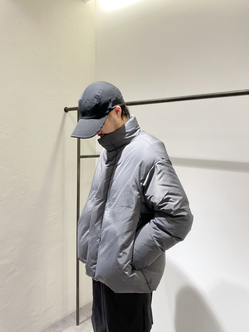 グレー系のダウンジャケット/コート、ブラック系のカーゴパンツ、ブラック系のスニーカーを着用したメンズの冬コーディネートの3枚目の写真