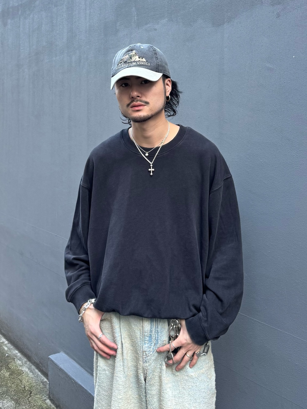 ブラック系のスウェット、ブラック系のその他シューズ、ブルー系のデニムパンツを着用したメンズの秋コーディネートの4枚目の写真