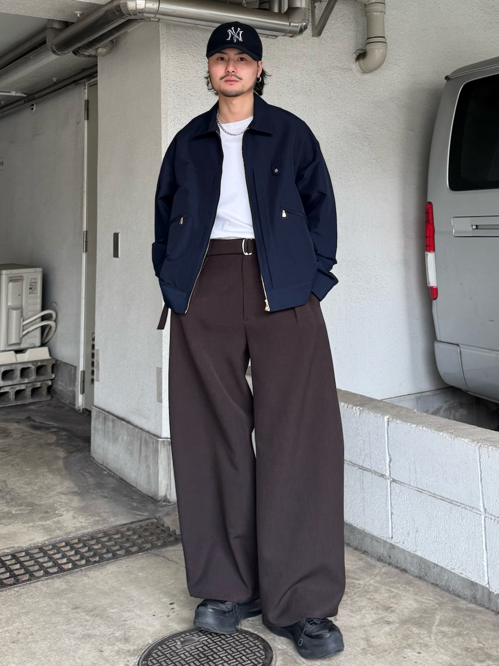 ブルー系のブルゾン、グレー系のスラックスを着用したメンズの春コーディネートの2枚目の写真