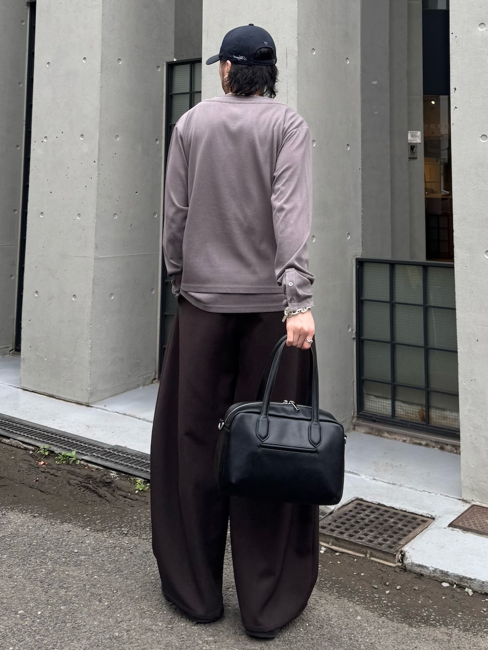 グレー系のスラックス、グレー系のTシャツ/カットソー、ブラック系のショルダーバッグを着用したメンズの春コーディネートの3枚目の写真