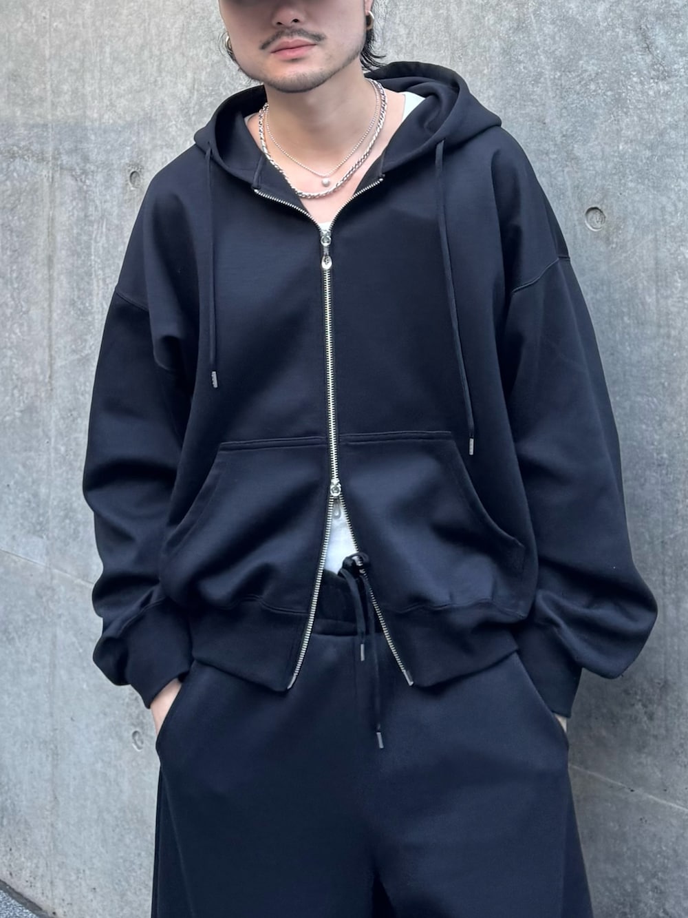 ブラック系のパーカー、ブラック系のローファー、ブラック系のその他パンツを着用したメンズの冬コーディネートの8枚目の写真