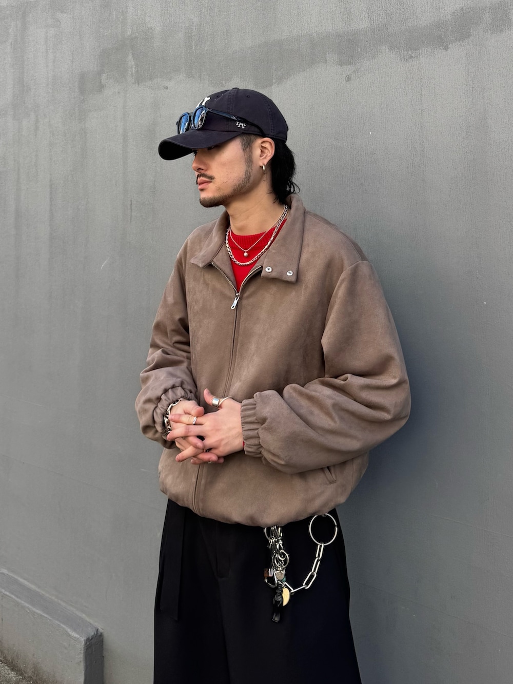 レッド系のニット/セーター、グレー系のブルゾン、ブラック系のスラックスを着用したメンズの冬コーディネートの5枚目の写真