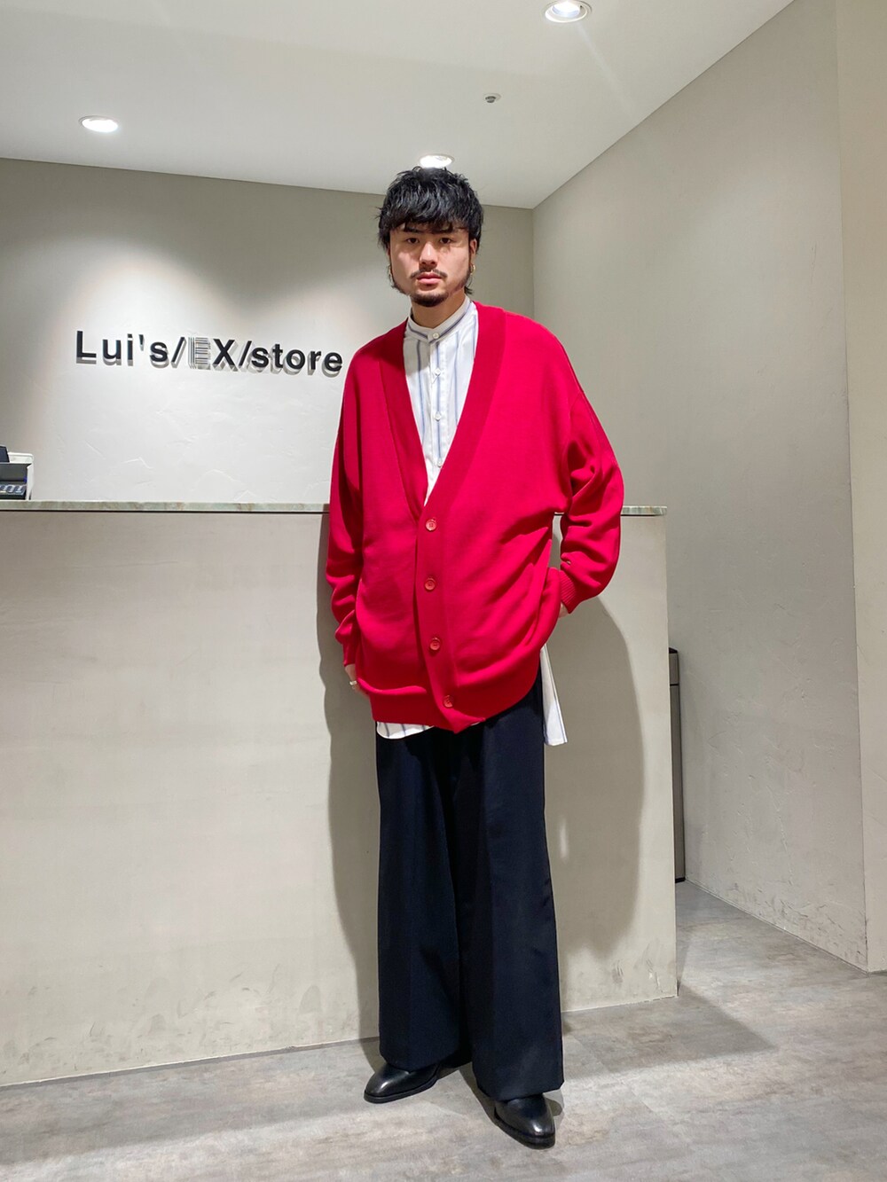 レッド系のカーディガン/ボレロ、ホワイト系のシャツ/ブラウス、ブラック系のスラックスを着用したメンズの春コーディネートの3枚目の写真