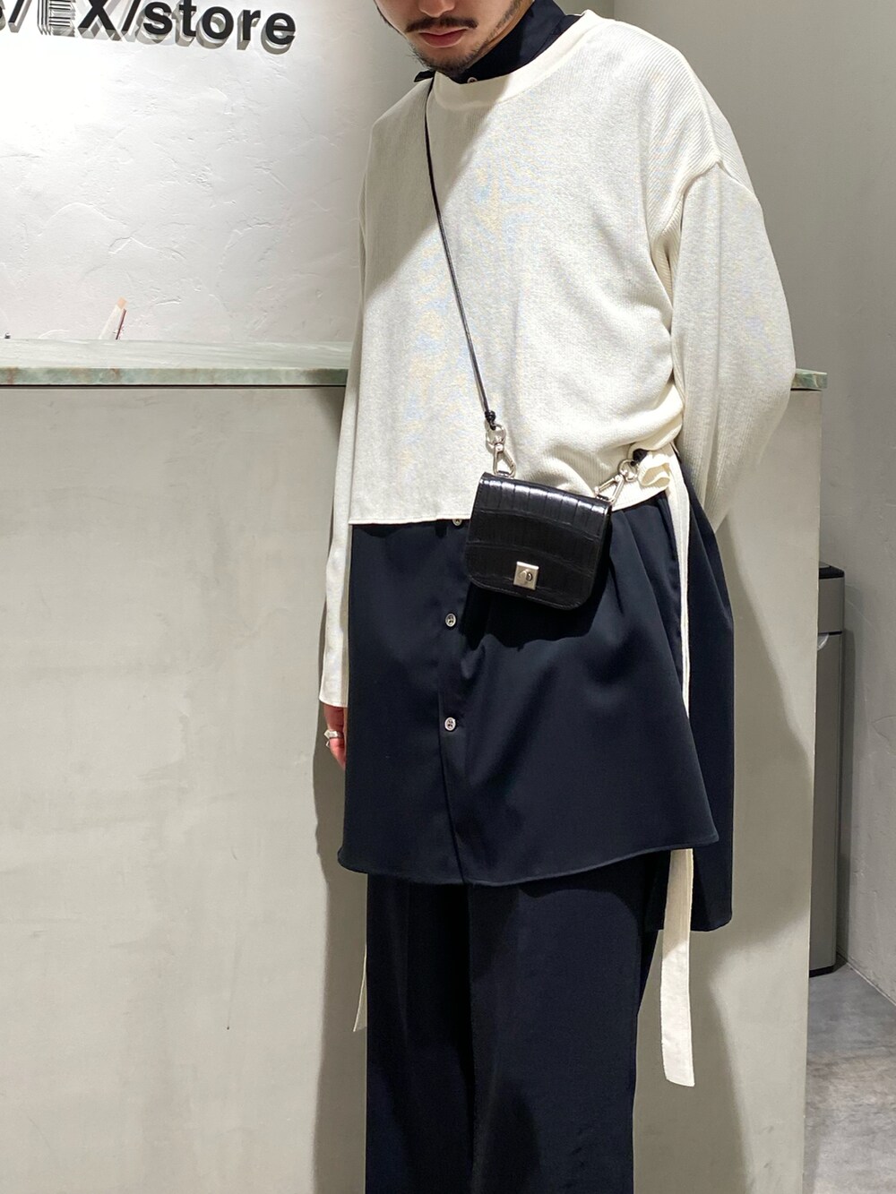 ベージュ系のトップス、ブラック系のシャツ/ブラウス、ブラック系のスラックスを着用したメンズの春コーディネートの3枚目の写真