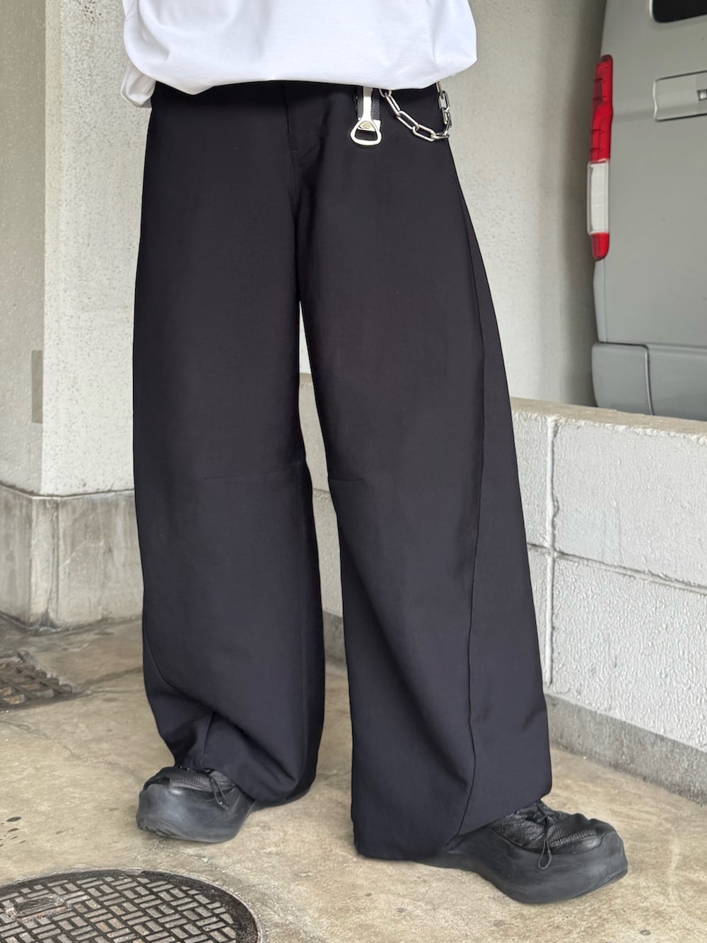 ホワイト系のTシャツ/カットソー、ブラック系のスラックスを着用したメンズの夏コーディネートの4枚目の写真