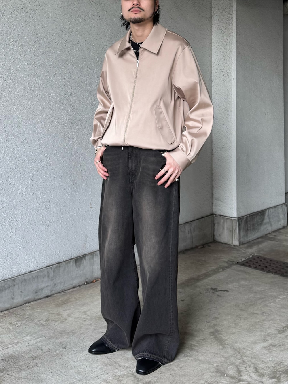 ブラック系のTシャツ/カットソー、ベージュ系のブルゾン、ブラック系のデニムパンツを着用したメンズの春コーディネートの3枚目の写真