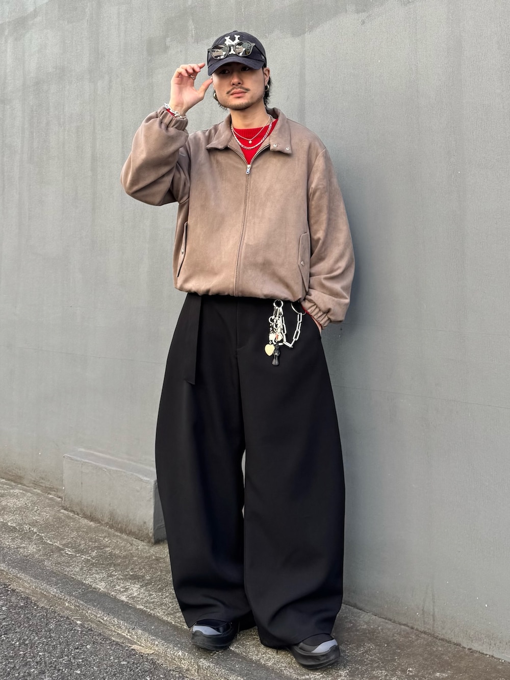 レッド系のニット/セーター、グレー系のブルゾン、ブラック系のスラックスを着用したメンズの冬コーディネートの2枚目の写真