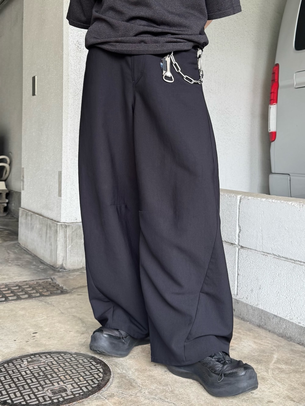 ブラック系のニット/セーター、ブラック系のスラックスを着用したメンズの夏コーディネートの4枚目の写真