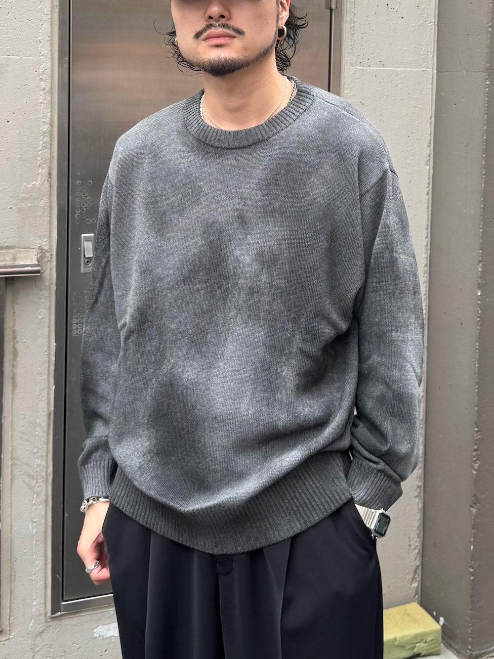 グレー系のニット/セーター、ブラック系のスラックスを着用したメンズの夏コーディネートの3枚目の写真