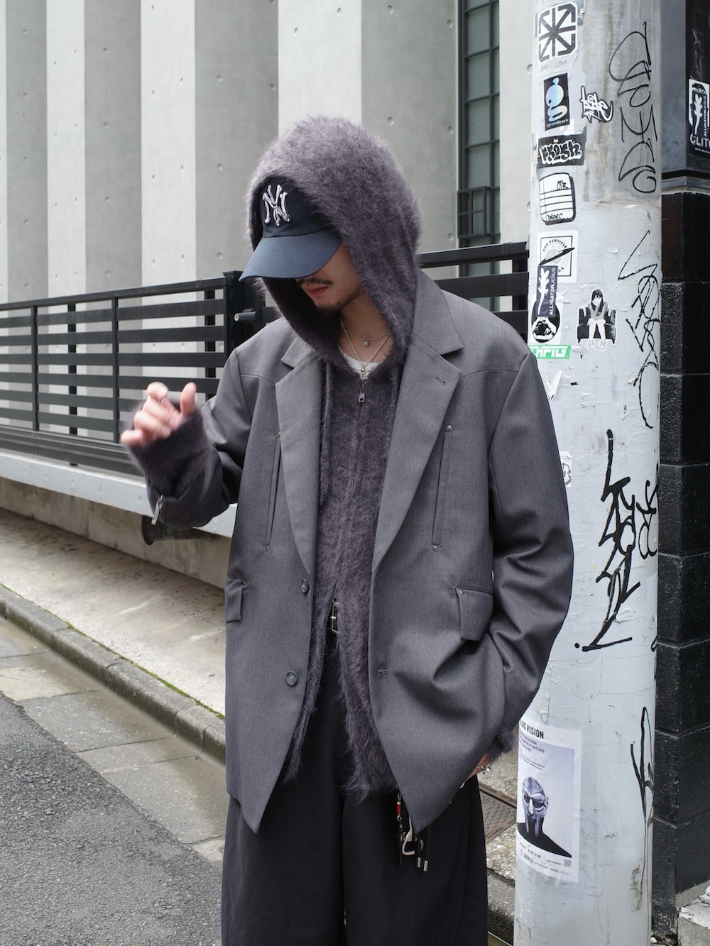 グレー系のテーラードジャケット、ブラック系のスラックス、グレー系のニット/セーターを着用したメンズの秋コーディネートの6枚目の写真