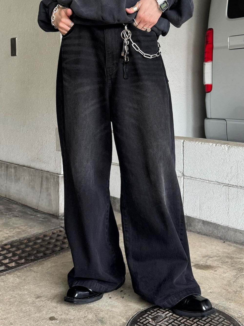 グレー系のスウェット、ブラック系のデニムパンツを着用したメンズの春コーディネートの4枚目の写真