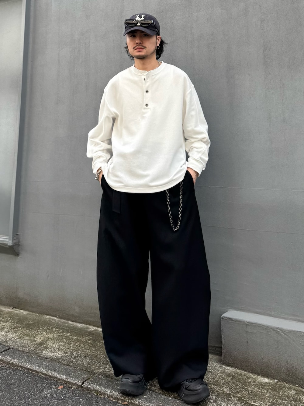 ホワイト系のTシャツ/カットソー、ブラック系のスラックス、ブラック系のウォレットチェーンを着用したメンズの春コーディネートの2枚目の写真