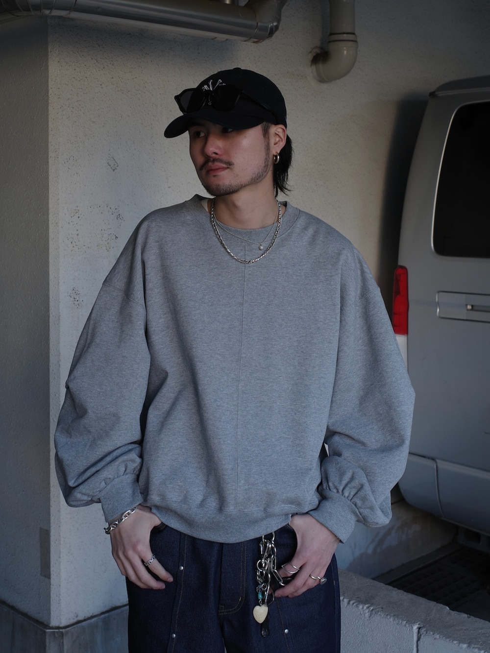 グレー系のスウェット、ブルー系のデニムパンツを着用したメンズの春コーディネートの4枚目の写真