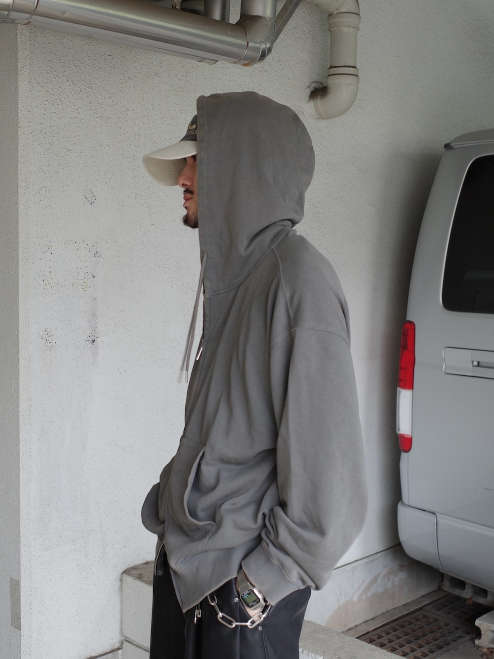 グレー系のパーカー、ブラック系のその他パンツを着用したメンズの秋コーディネートの6枚目の写真