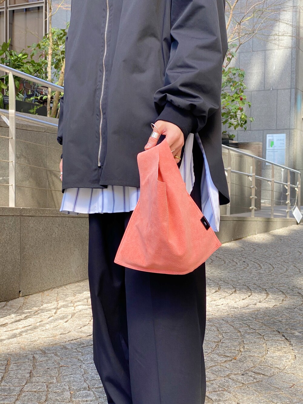 ブラック系のシャツ/ブラウス、ホワイト系のシャツ/ブラウス、ブラック系のスラックスを着用したメンズの春コーディネートの5枚目の写真