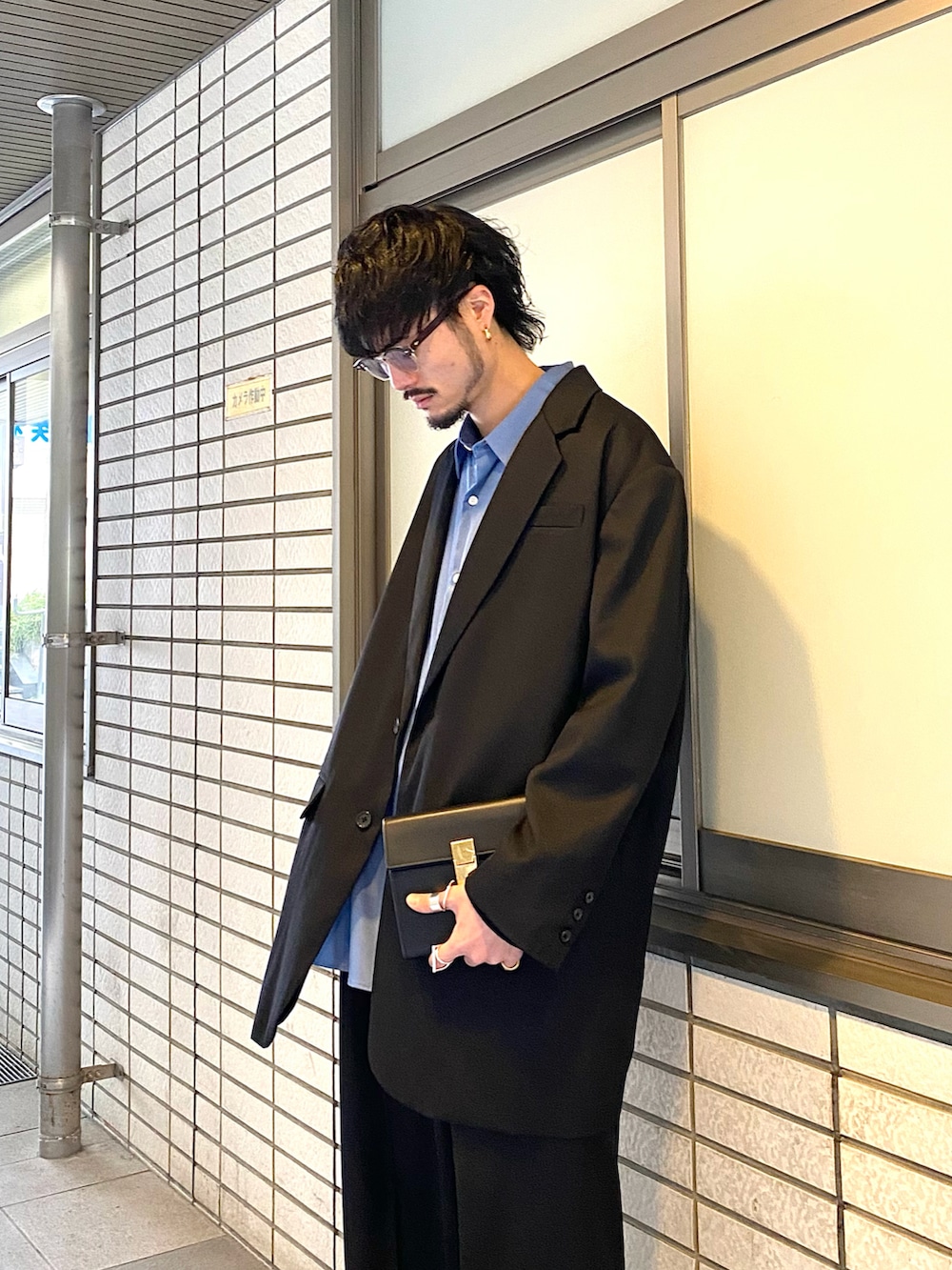 ブラック系のテーラードジャケット、ブラック系のスラックス、ブルー系のシャツ/ブラウスを着用したメンズの冬コーディネートの3枚目の写真