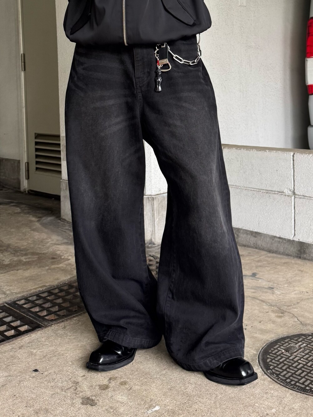 ブラック系のブルゾン、ブラック系のデニムパンツを着用したメンズの夏コーディネートの4枚目の写真