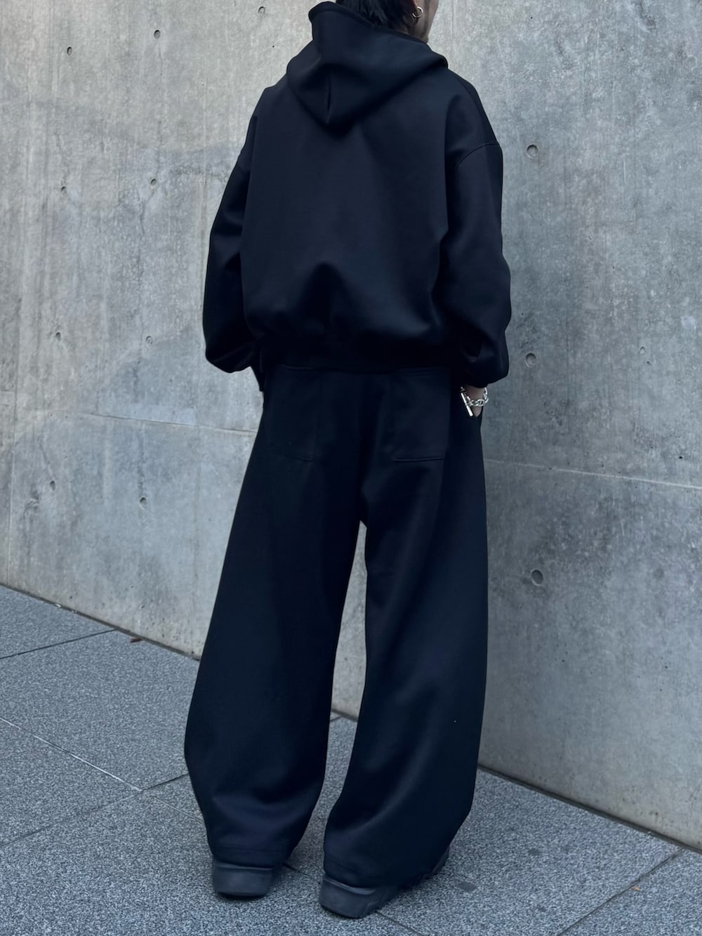 ブラック系のパーカー、ブラック系のローファー、ブラック系のその他パンツを着用したメンズの冬コーディネートの6枚目の写真