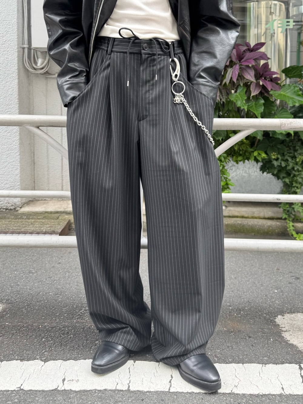 ブラック系のブルゾン、ブラック系のスラックス、シルバー系のウォレットチェーンを着用したメンズの秋コーディネートの5枚目の写真