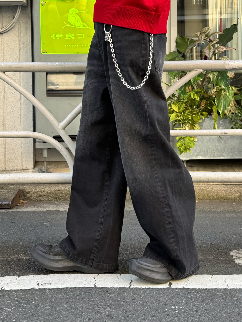 レッド系のニット/セーター、ブラック系のデニムパンツ、シルバー系の財布/小物を着用したメンズの冬コーディネートの4枚目の写真