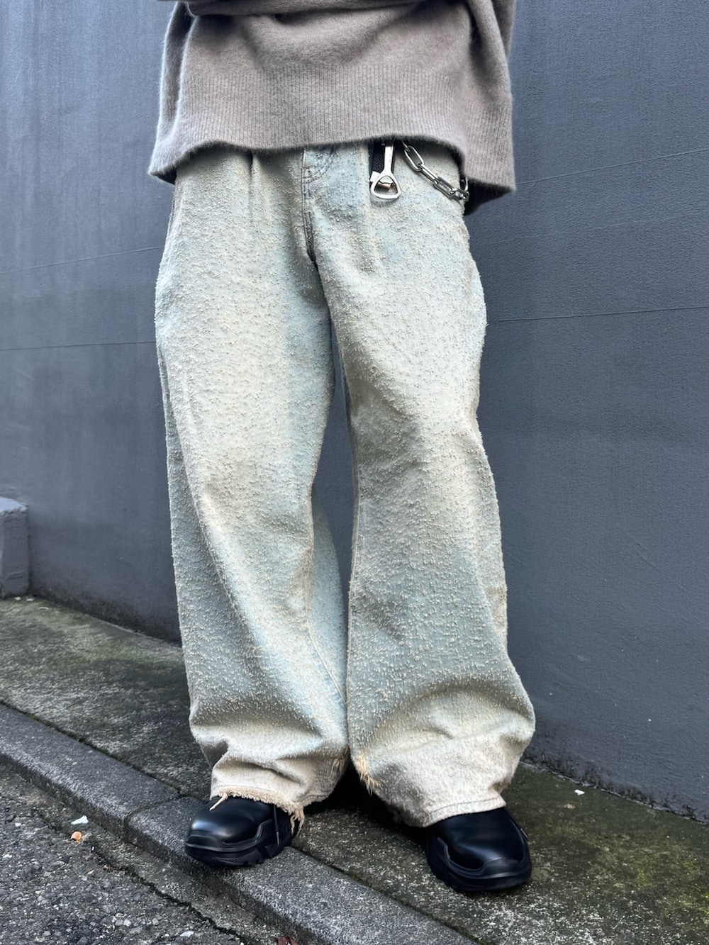 ブラウン系のニット/セーター、ブルー系のデニムパンツ、ブラック系のその他シューズを着用したメンズの秋コーディネートの6枚目の写真