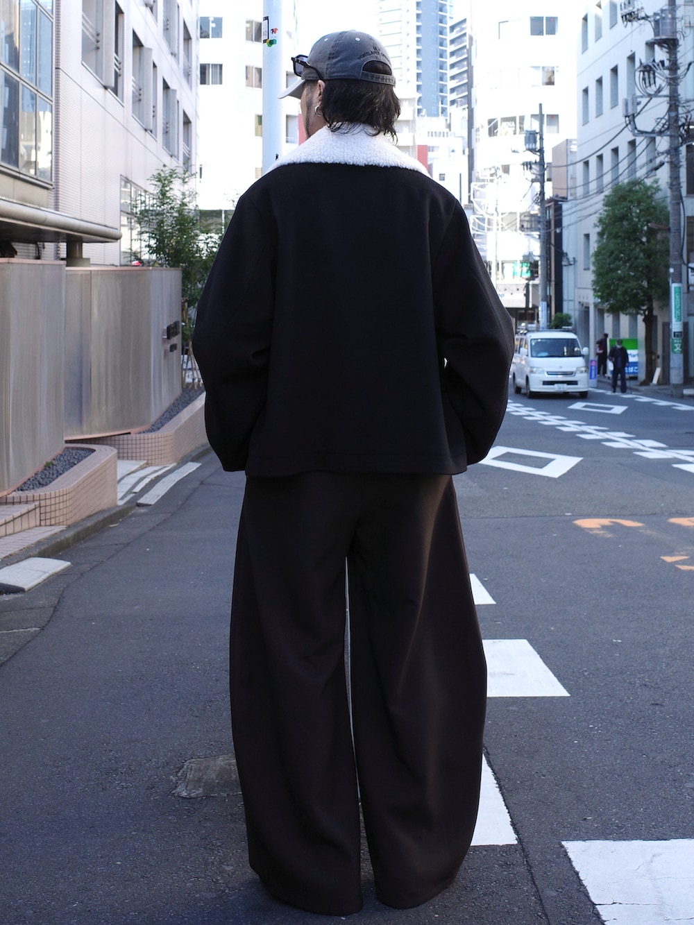 グレー系のニット/セーター、ブラック系のブルゾン、グレー系のスラックスを着用したメンズの秋コーディネートの3枚目の写真