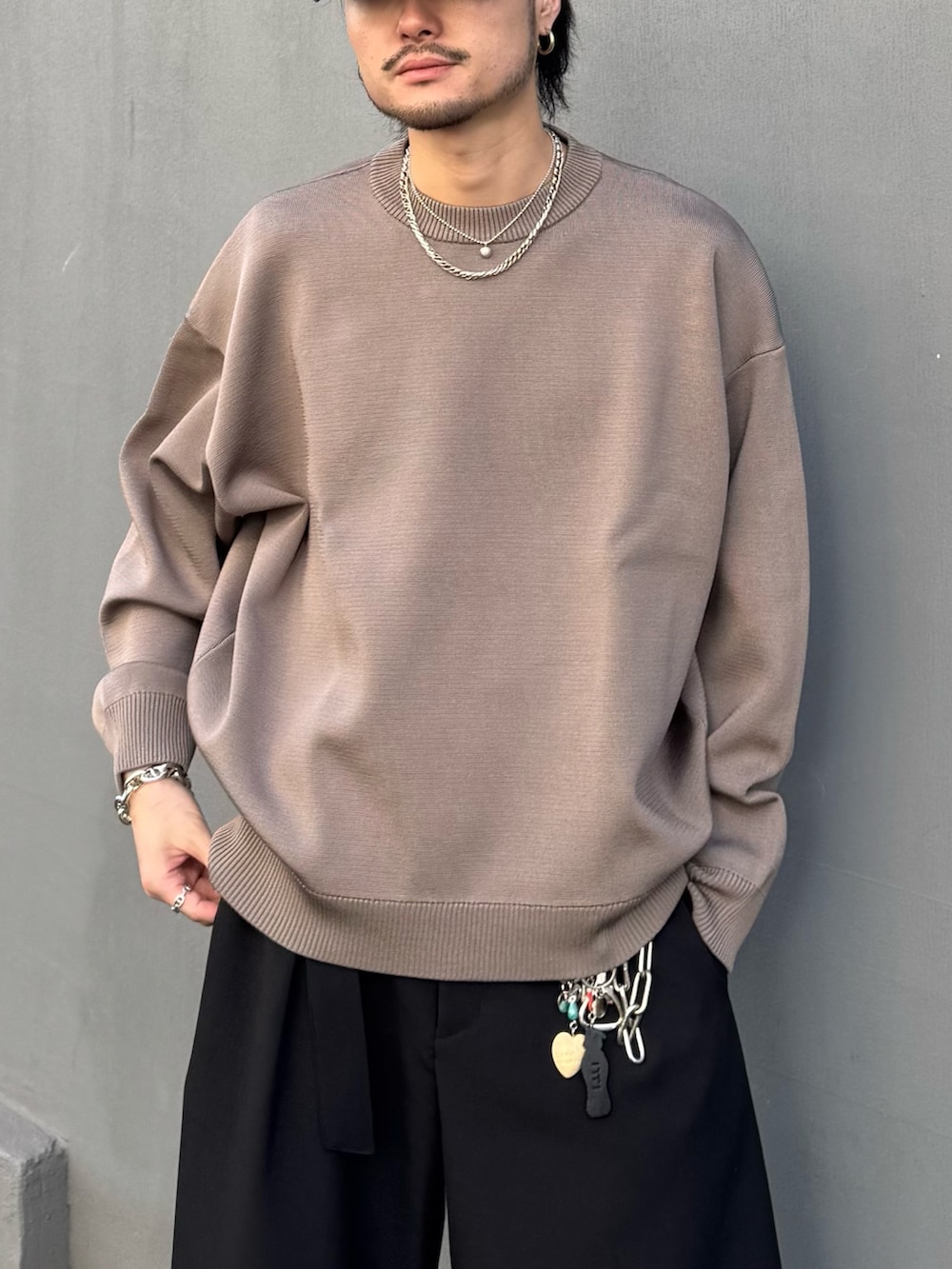 ブラウン系のニット/セーター、ブラック系のその他パンツを着用したメンズの冬コーディネートの6枚目の写真