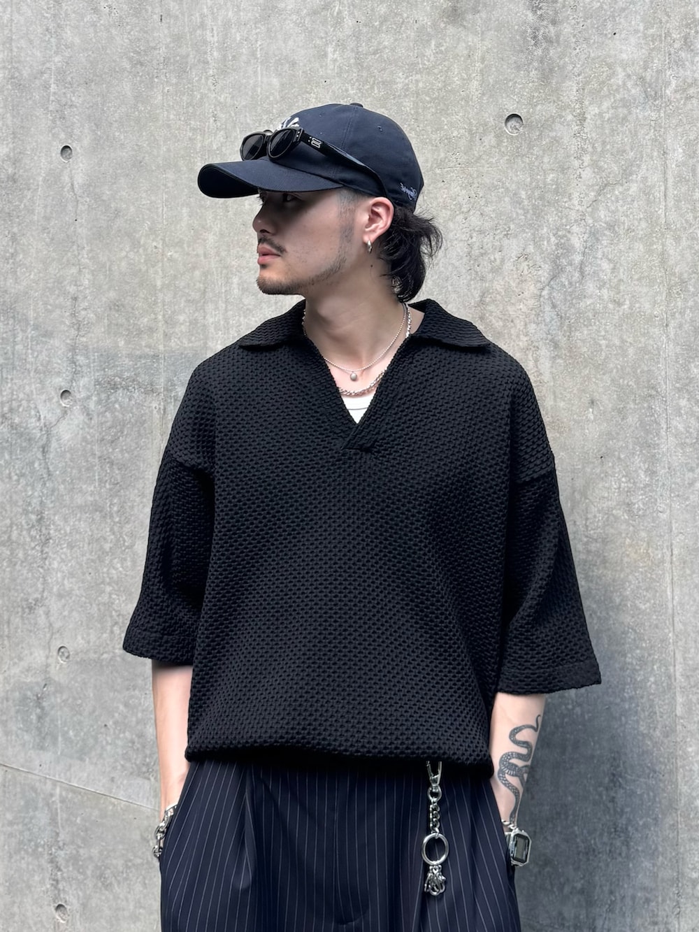 ブラック系のニット/セーター、ブラック系のその他シューズ、ブルー系のスラックスを着用したメンズの夏コーディネートの4枚目の写真