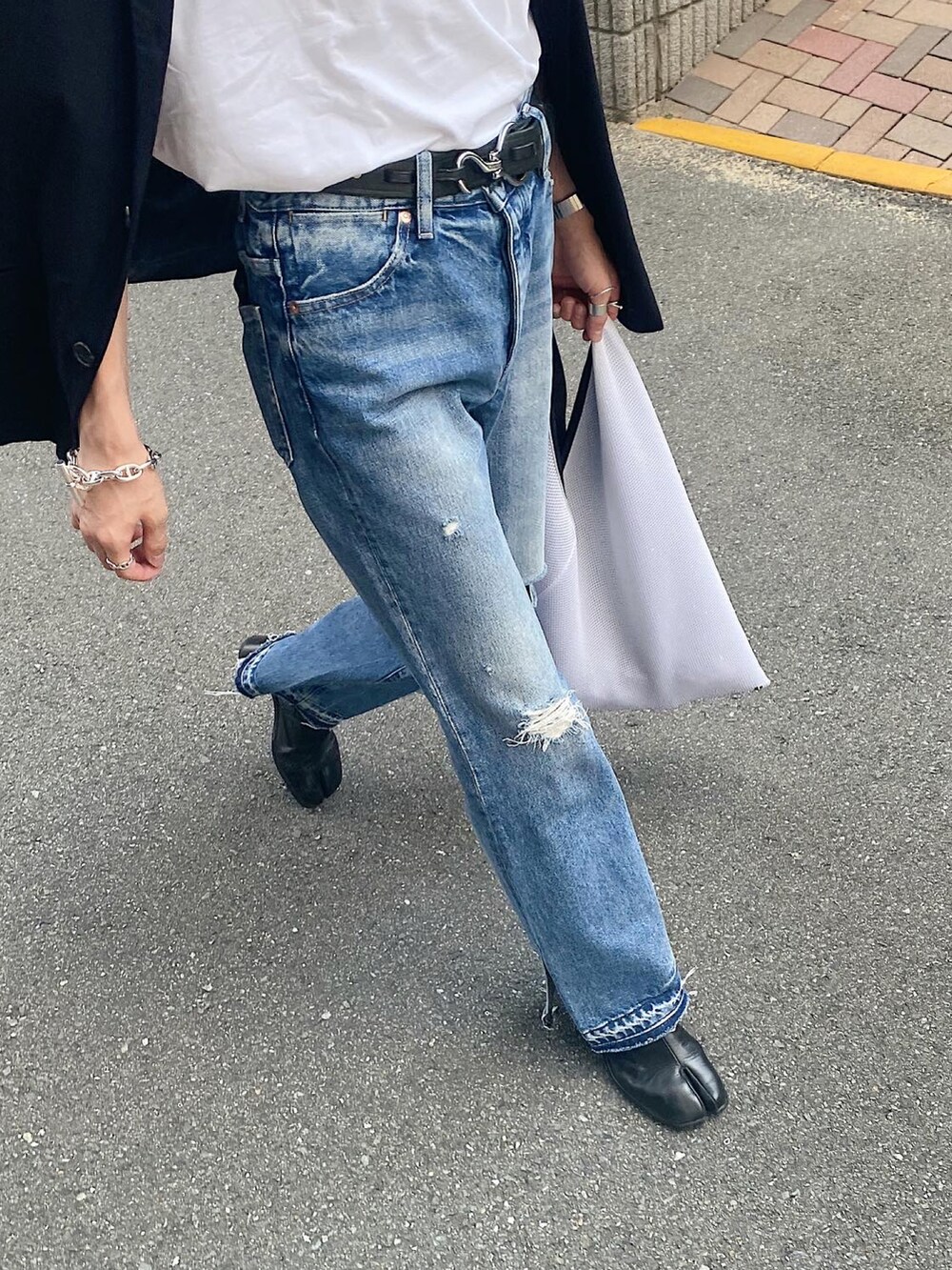 ホワイト系のTシャツ/カットソー、ブルー系のデニムパンツ、ホワイト系のバッグを着用したメンズの秋コーディネートの2枚目の写真