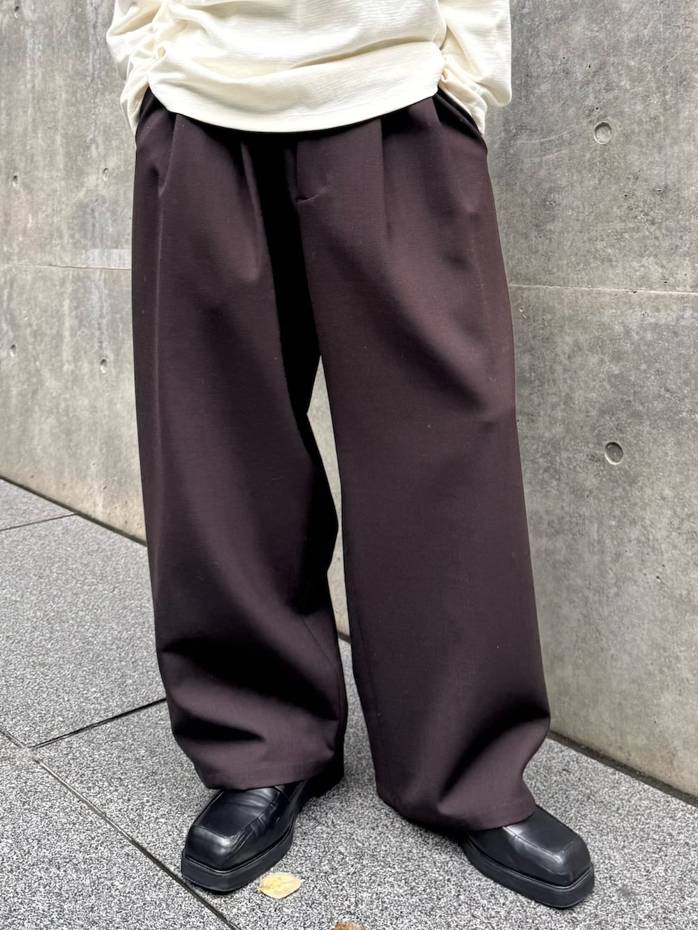 ホワイト系のTシャツ/カットソー、ブラウン系のスラックス、ブラック系のローファーを着用したメンズの秋コーディネートの5枚目の写真