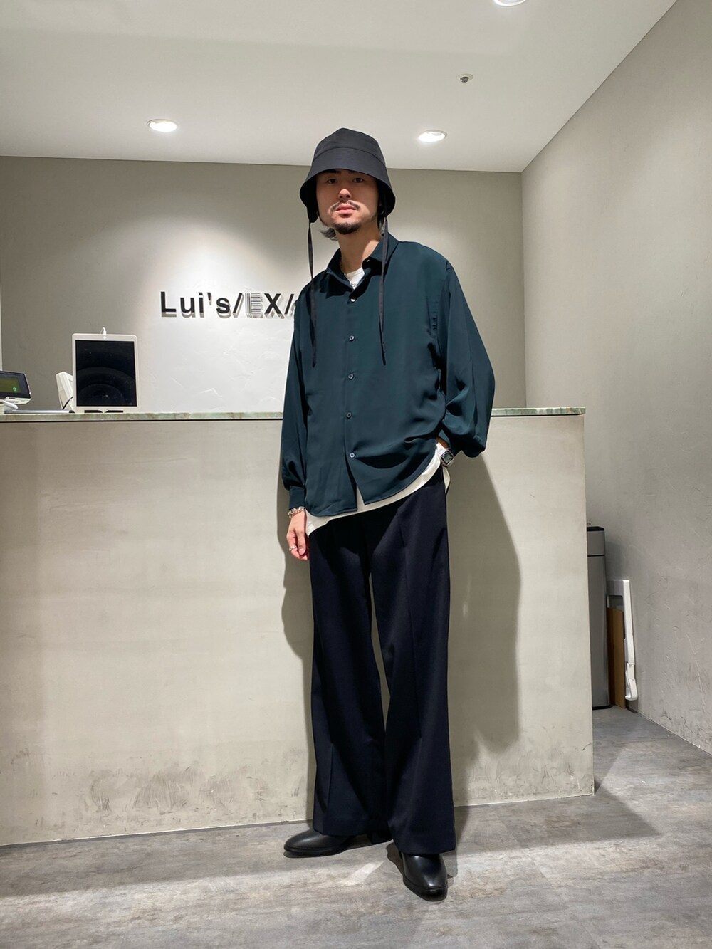 グリーン系のシャツ/ブラウス、ブラック系のスラックス、ブラック系のドレスシューズを着用したメンズの夏コーディネートの2枚目の写真