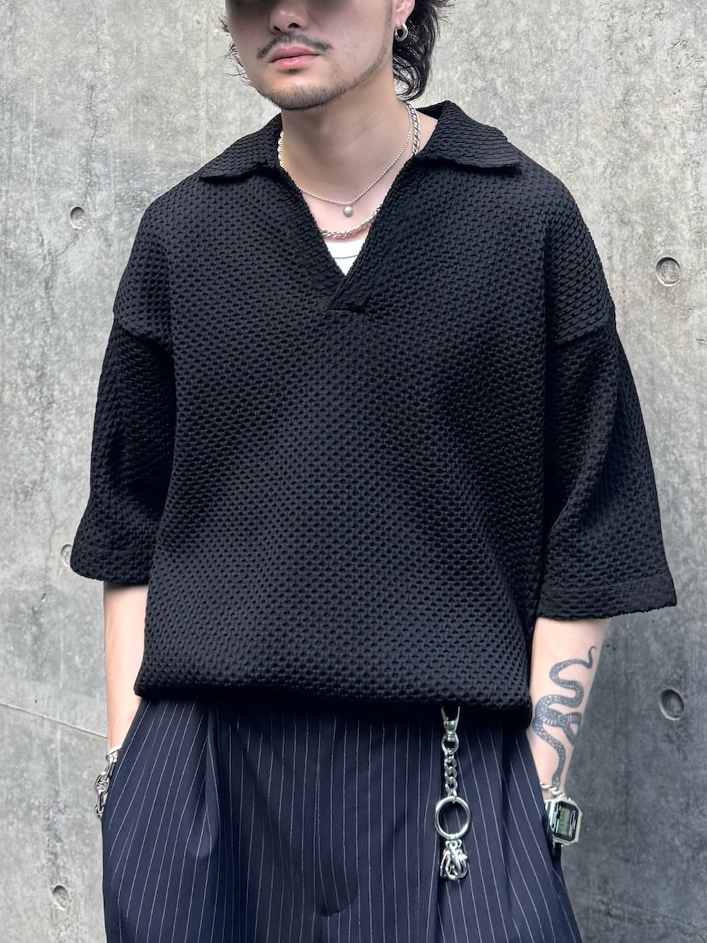 ブラック系のニット/セーター、ブラック系のその他シューズ、ブルー系のスラックスを着用したメンズの夏コーディネートの5枚目の写真