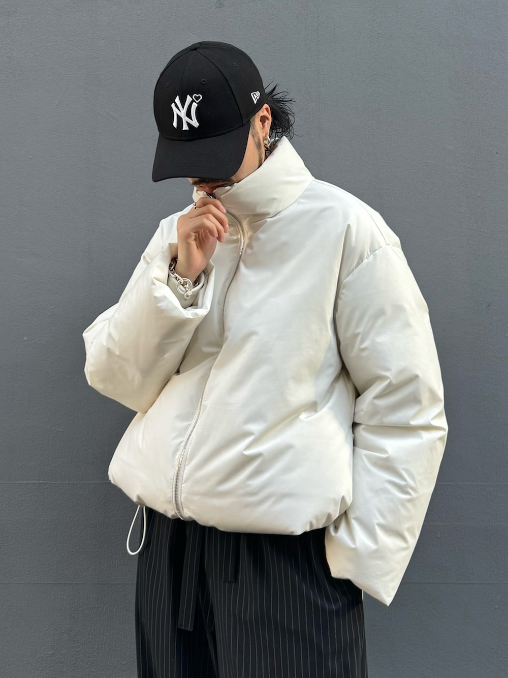 ホワイト系のブルゾン、ブラック系のその他パンツ、ブラック系のローファーを着用したメンズの冬コーディネートの3枚目の写真