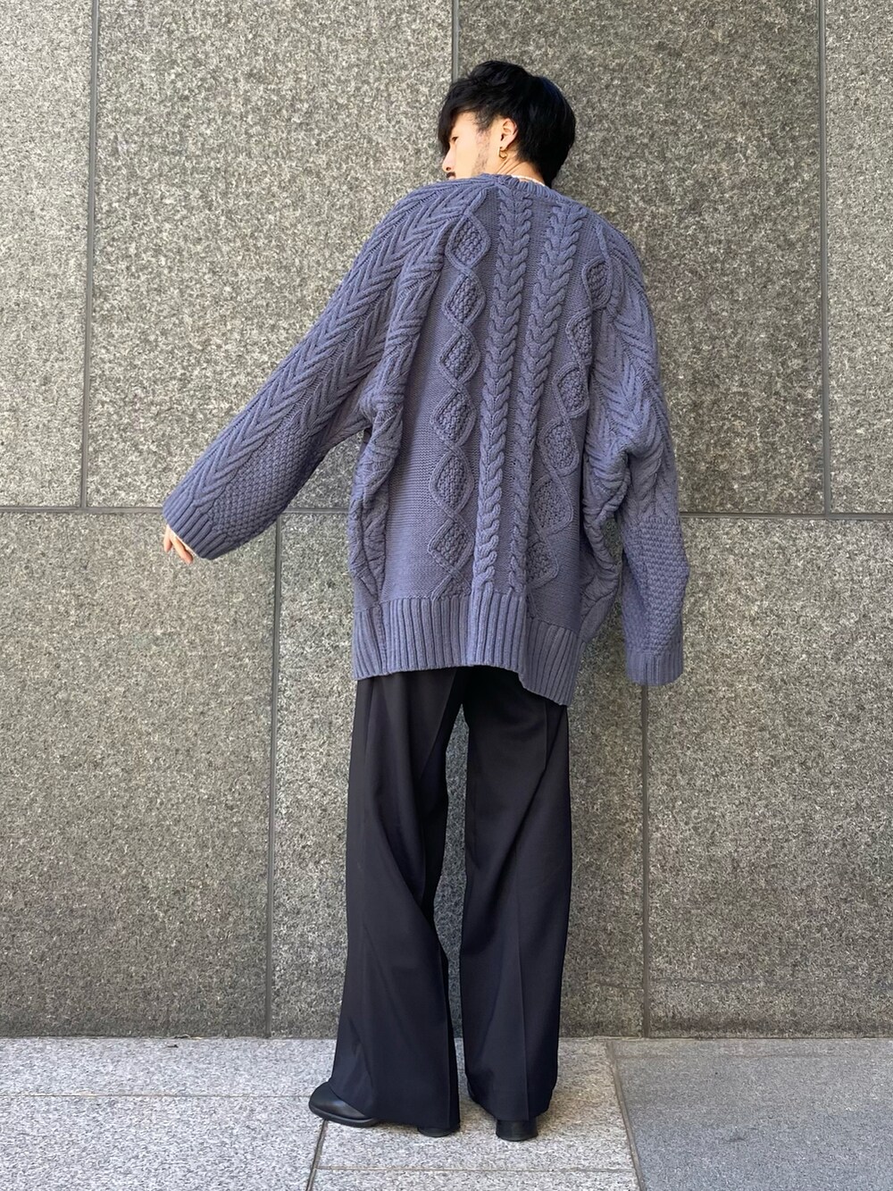 ブルー系のニット/セーター、ブラック系のスラックス、ブラック系の財布を着用したメンズの秋コーディネートの4枚目の写真