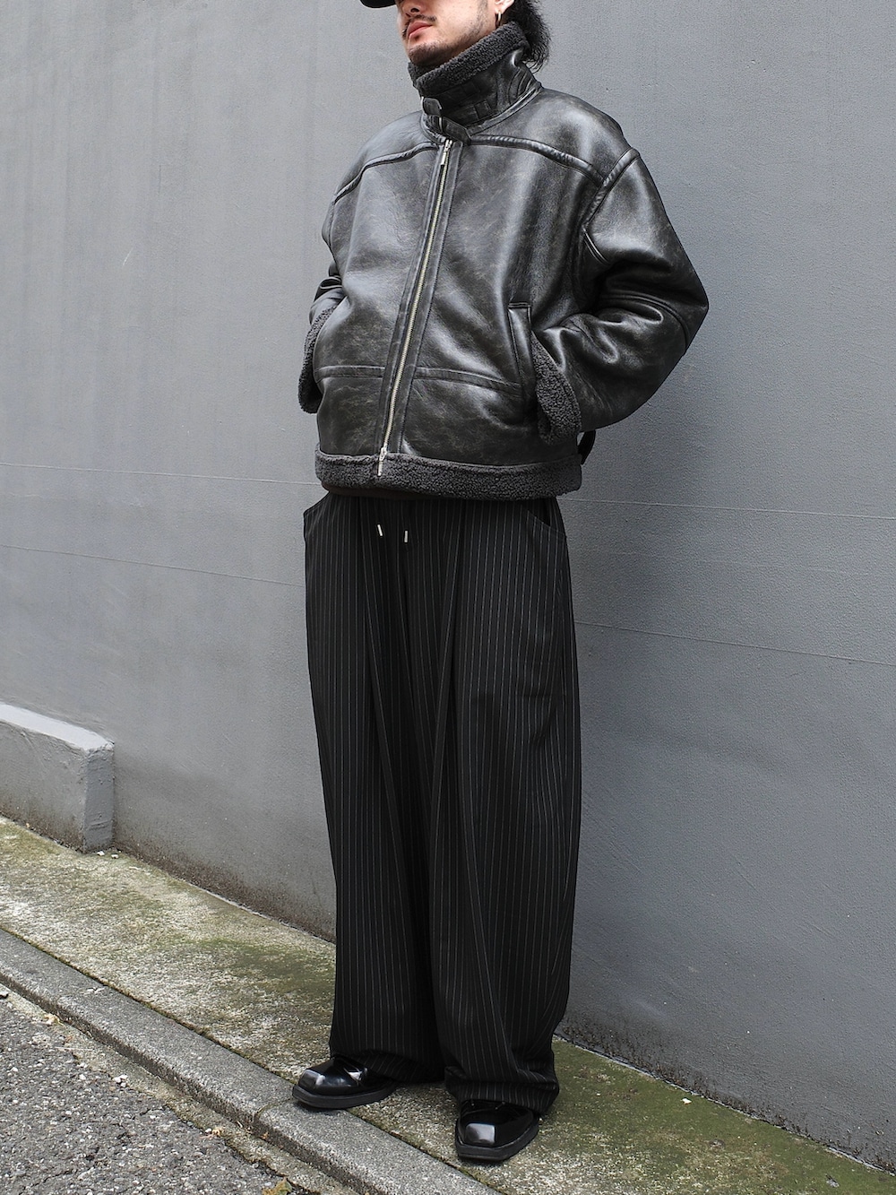 ブラック系のブルゾン、ブラック系のスラックスを着用したメンズの秋コーディネートの3枚目の写真