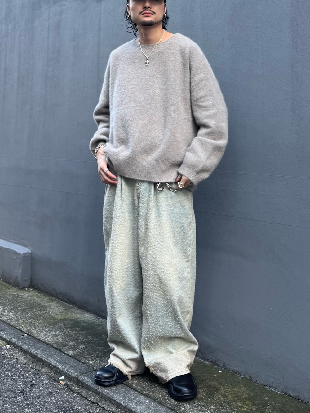 ブラウン系のニット/セーター、ブルー系のデニムパンツ、ブラック系のその他シューズを着用したメンズの秋コーディネートの2枚目の写真