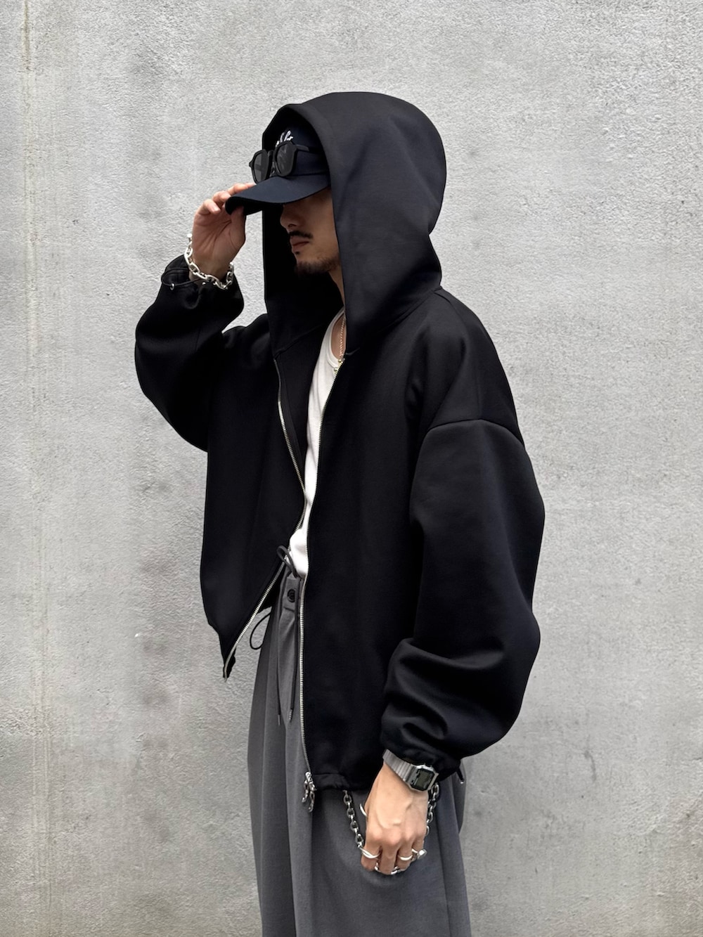 ブラック系のパーカー、グレー系のスラックス、シルバー系のウォレットチェーンを着用したメンズの秋コーディネートの6枚目の写真