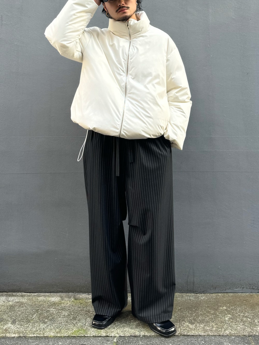 ホワイト系のブルゾン、ブラック系のその他パンツ、ブラック系のローファーを着用したメンズの冬コーディネートの2枚目の写真