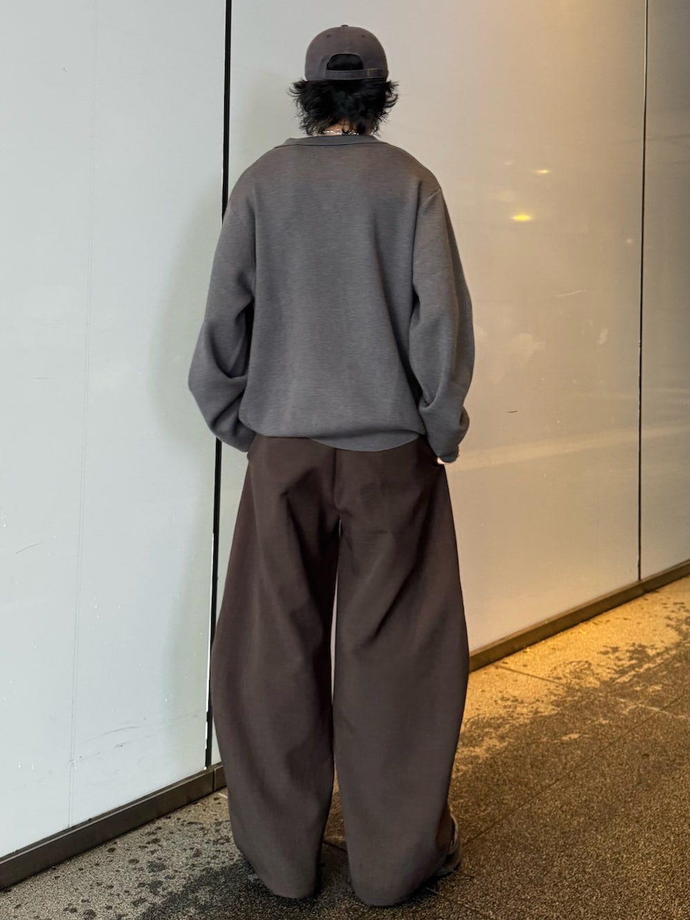 グレー系のニット/セーター、グレー系のスラックスを着用したメンズの秋コーディネートの3枚目の写真