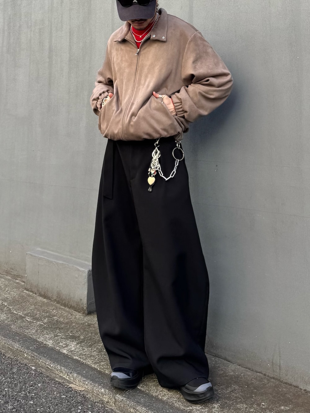 レッド系のニット/セーター、グレー系のブルゾン、ブラック系のスラックスを着用したメンズの冬コーディネートの4枚目の写真