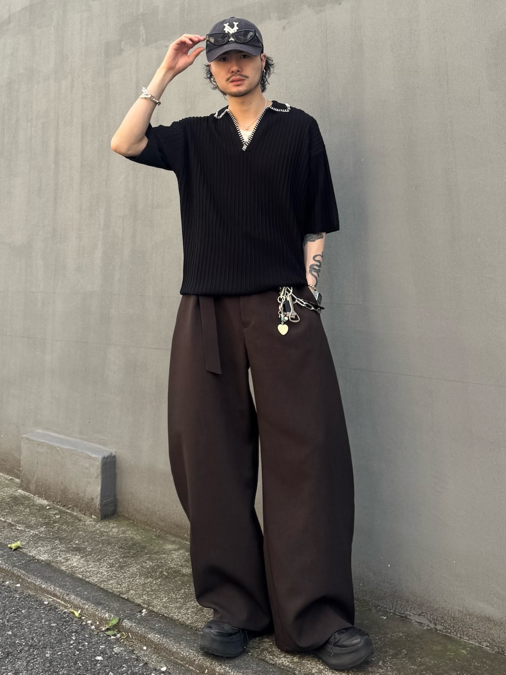 ブラック系のニット/セーター、グレー系のスラックスを着用したメンズの春コーディネートの2枚目の写真