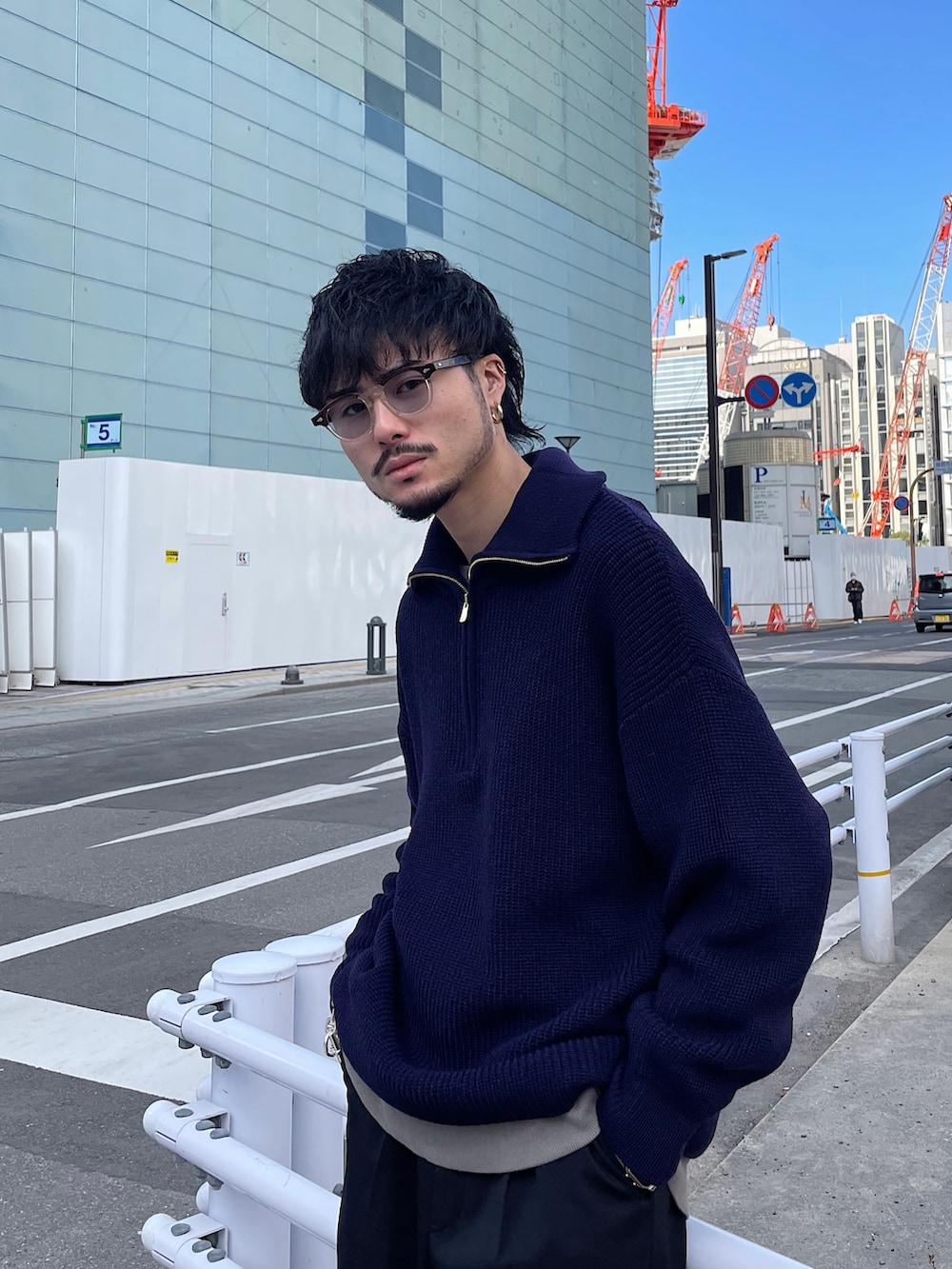 ブルー系のニット/セーター、ブラック系のスラックスを着用したメンズの冬コーディネートの2枚目の写真