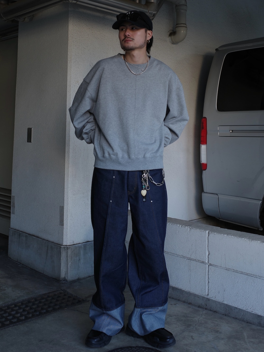 グレー系のスウェット、ブルー系のデニムパンツを着用したメンズの春コーディネートの2枚目の写真