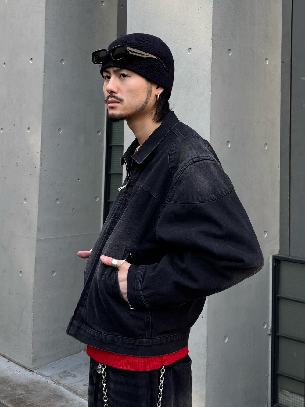 ブラック系のブルゾン、ブラック系のデニムパンツ、レッド系のニット/セーターを着用したメンズの冬コーディネートの4枚目の写真